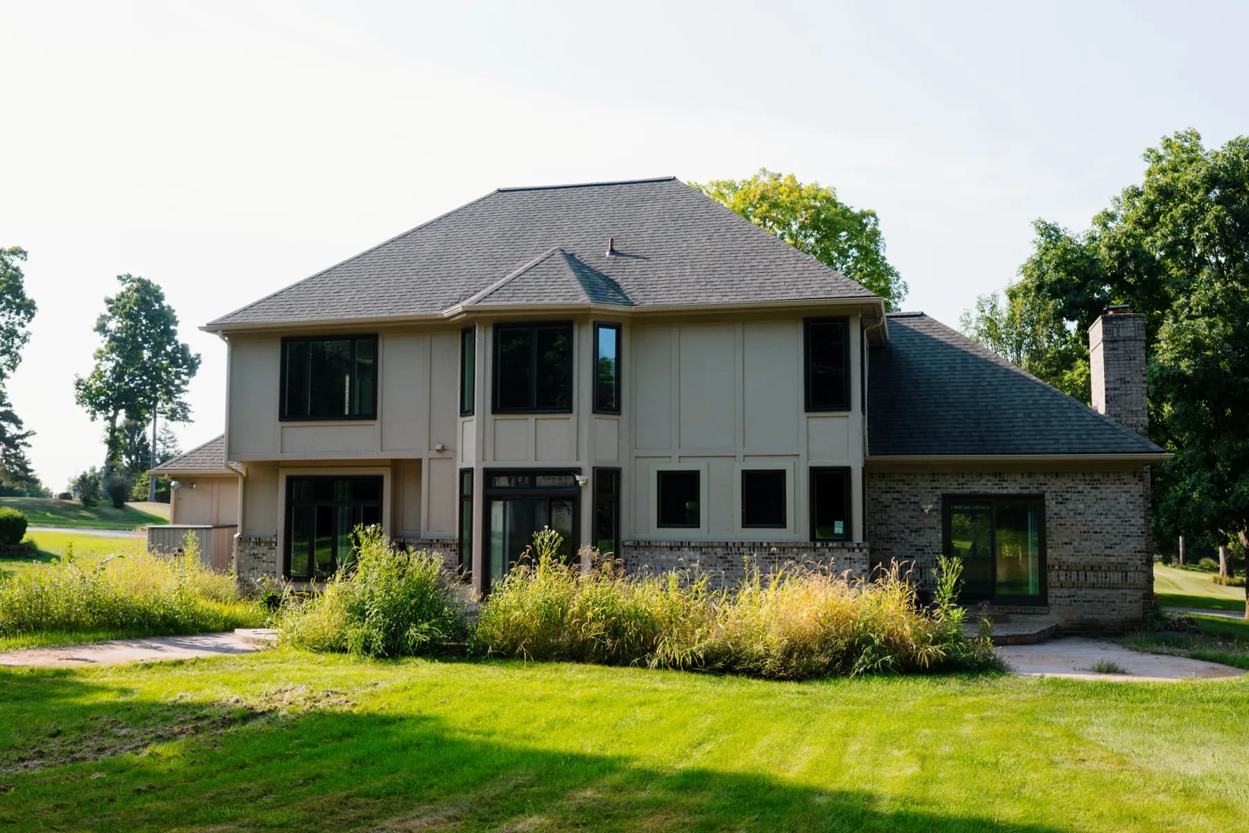 Stucco two-storey with a stone chimney and new windows, Canton