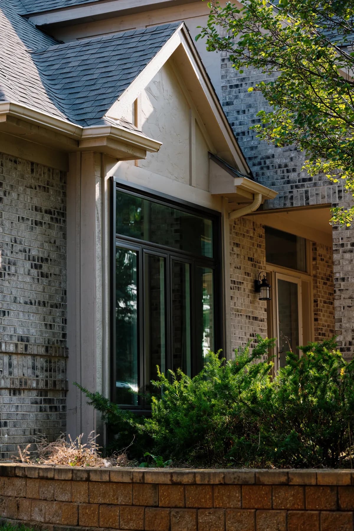 Black-framed windows and a covered entry on a brick two-storey in Livonia
