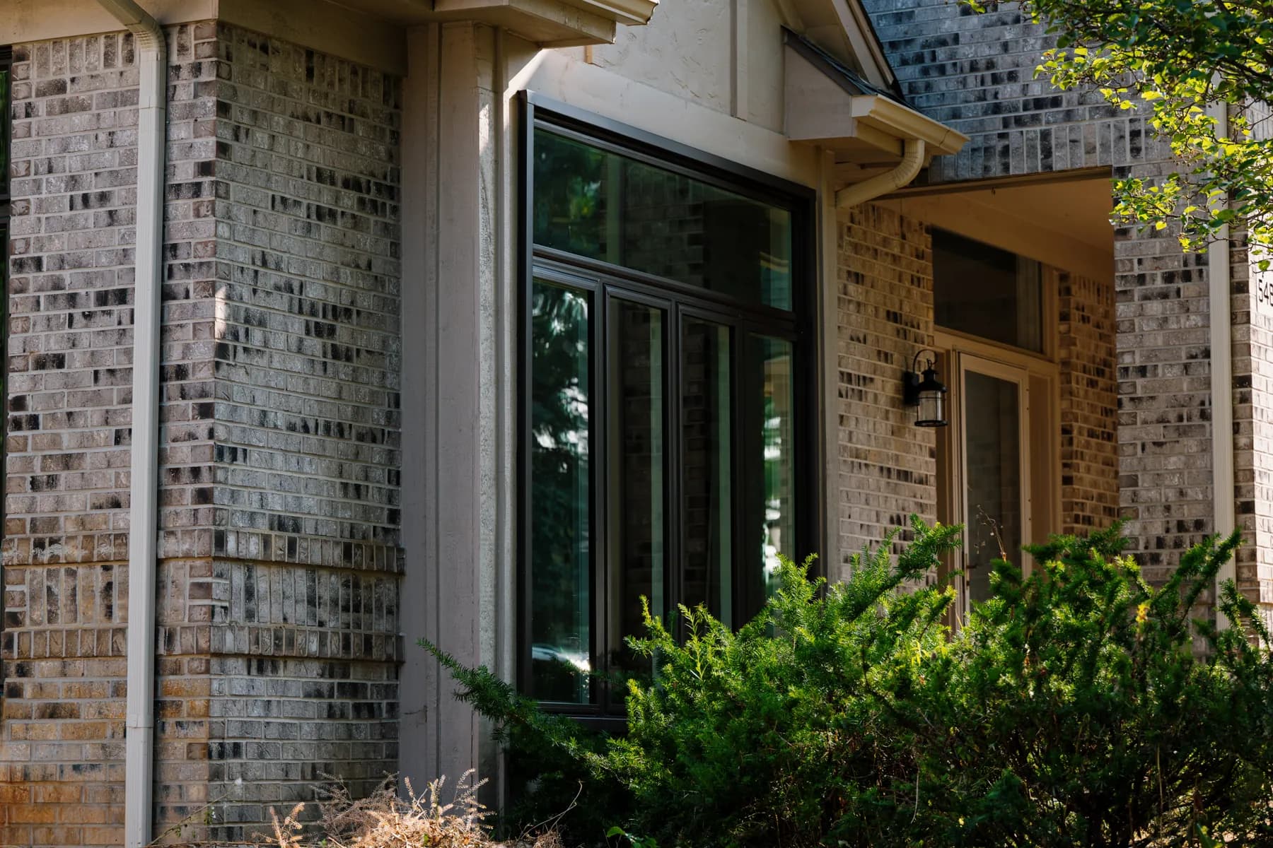 Front entry and black-framed windows on a Livonia brick two-storey
