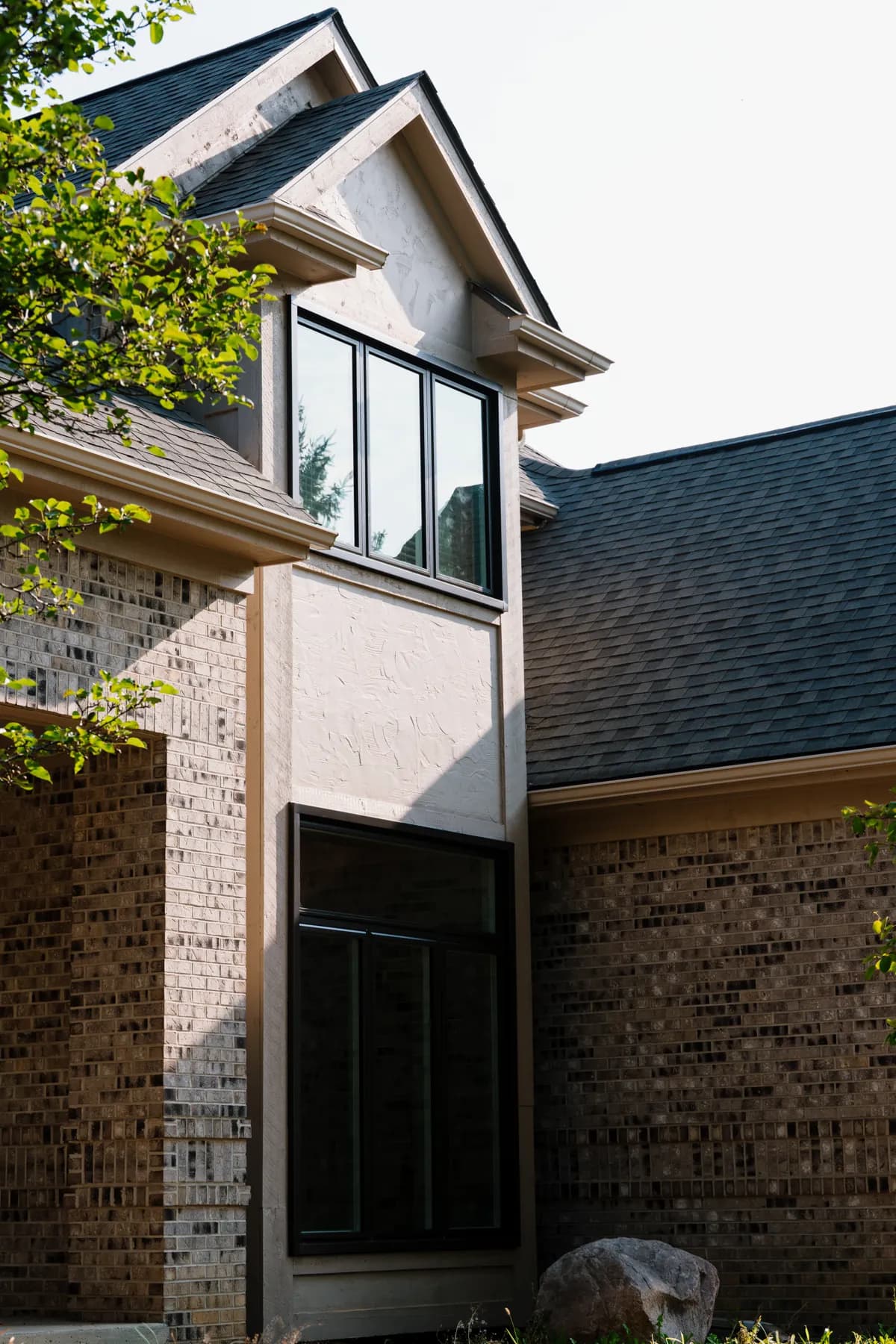Tall black-framed windows on the upper storey of a Livonia home