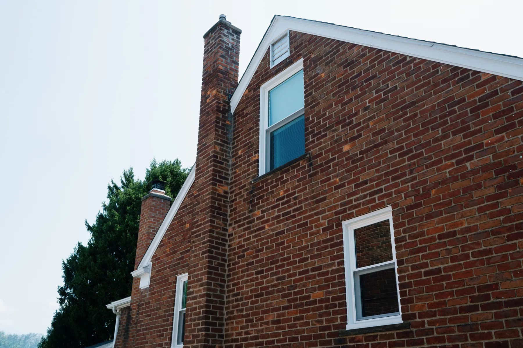 Upper and lower double-hung windows on a brick cape in Southgate