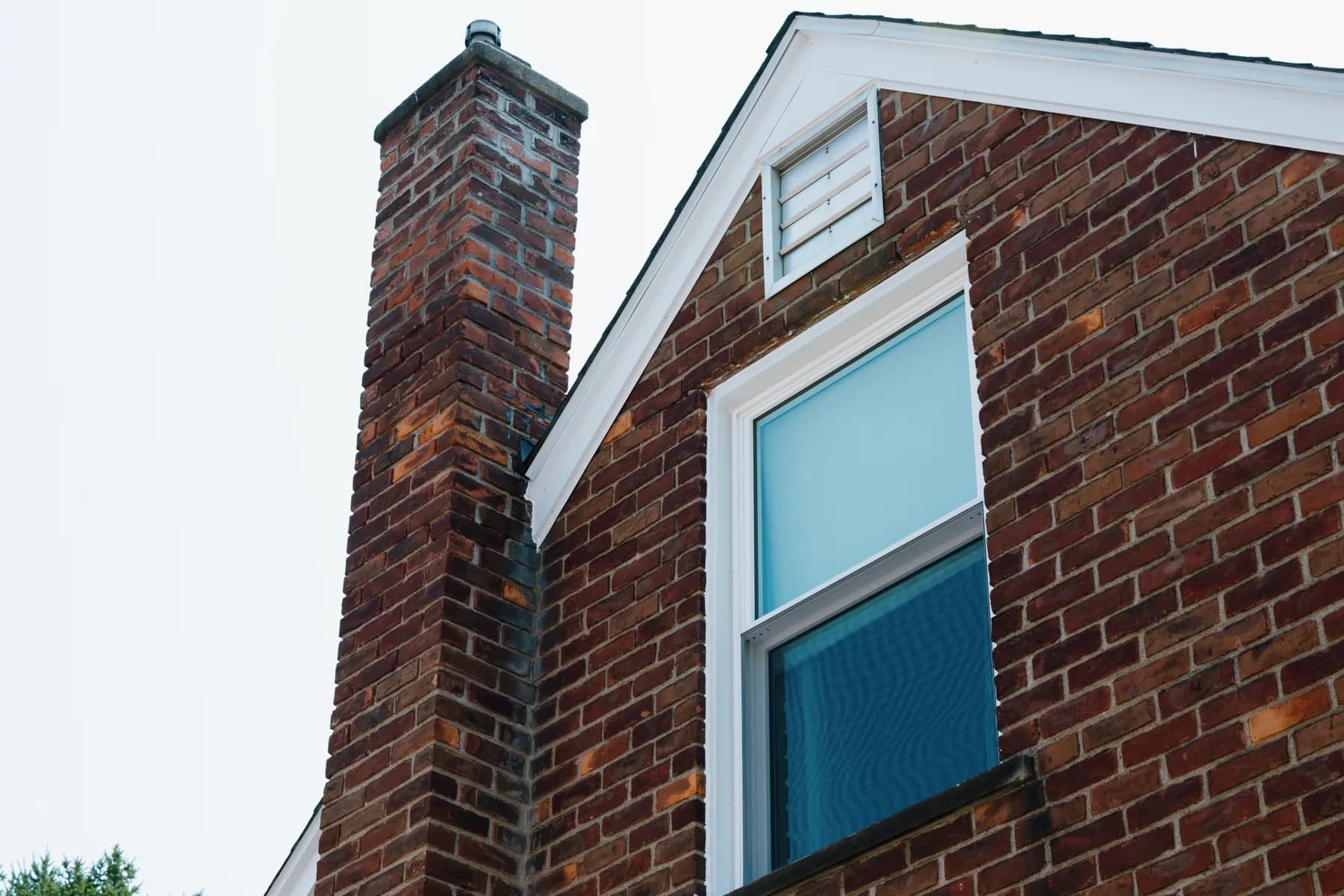 New double-hung window beside the chimney on a Southgate brick home