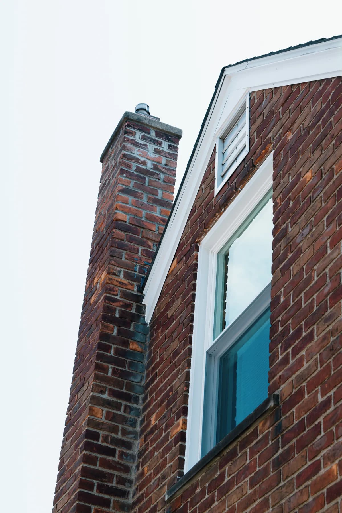 Chimney-side replacement window on a Southgate brick cape