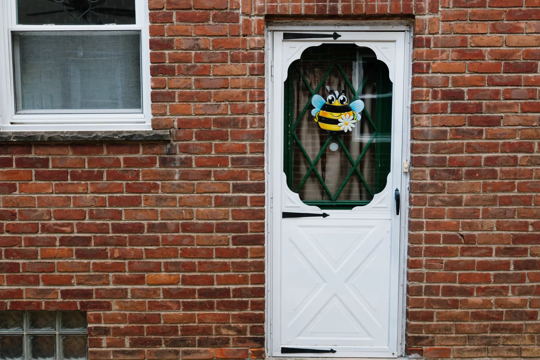 New storm door and double-hung window on a brick home in Southgate