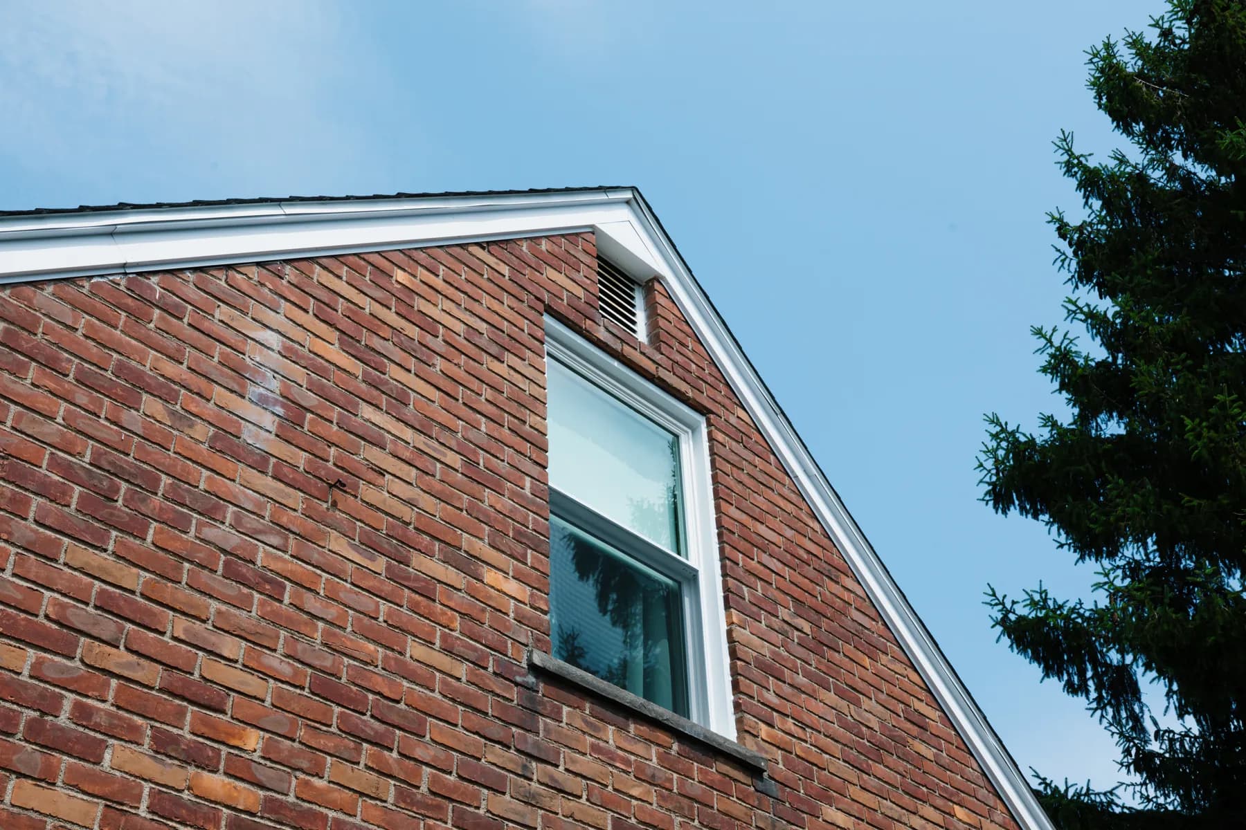 Gable-end double-hung window on a brick cape in Southgate