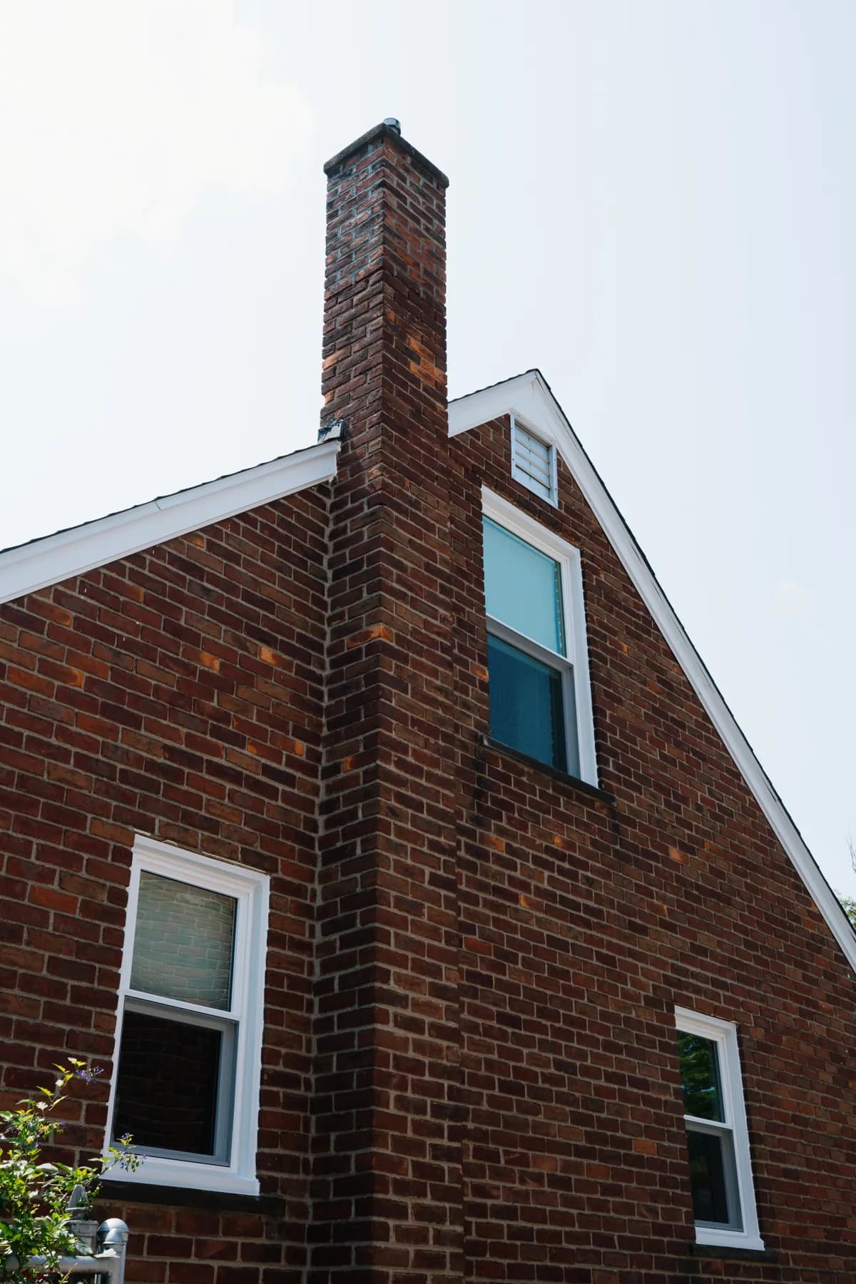Chimney-side double-hung windows on a brick cape in Southgate