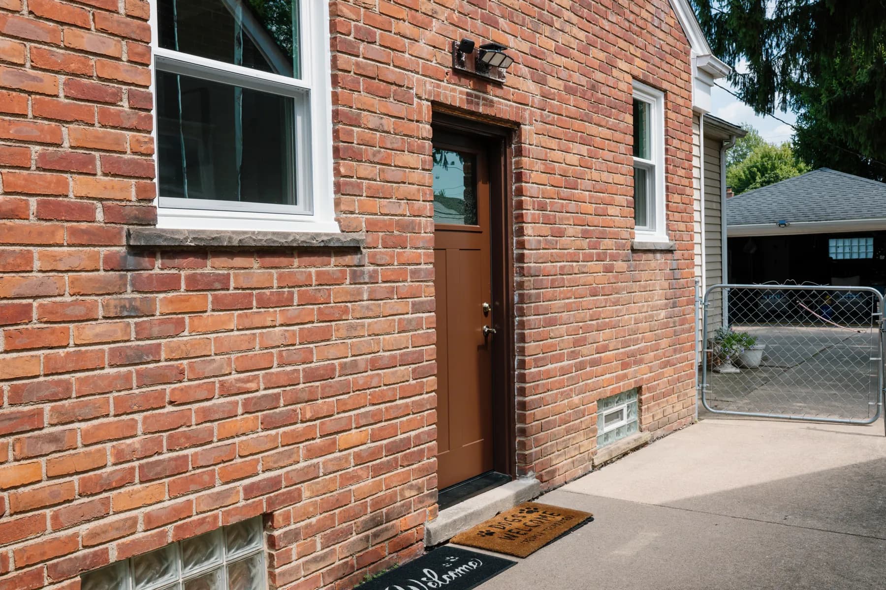 Side entry door and double-hung window on a brick cape in Southgate