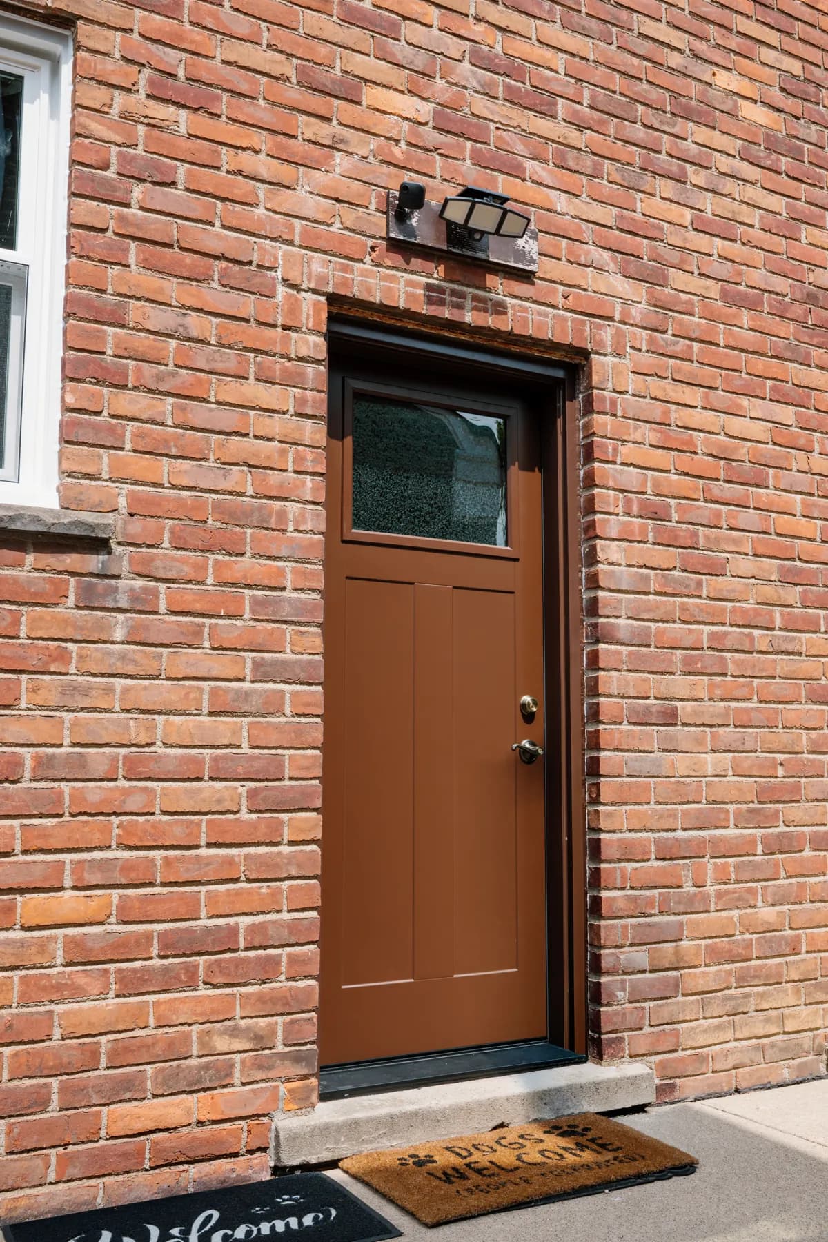 Brown entry door with a glass insert on a Southgate brick home