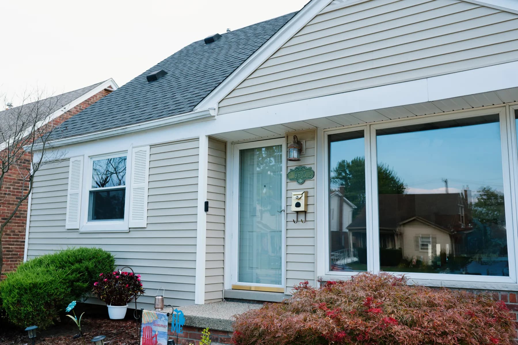 Picture window, double-hung, and storm door on a vinyl-sided cape in Taylor