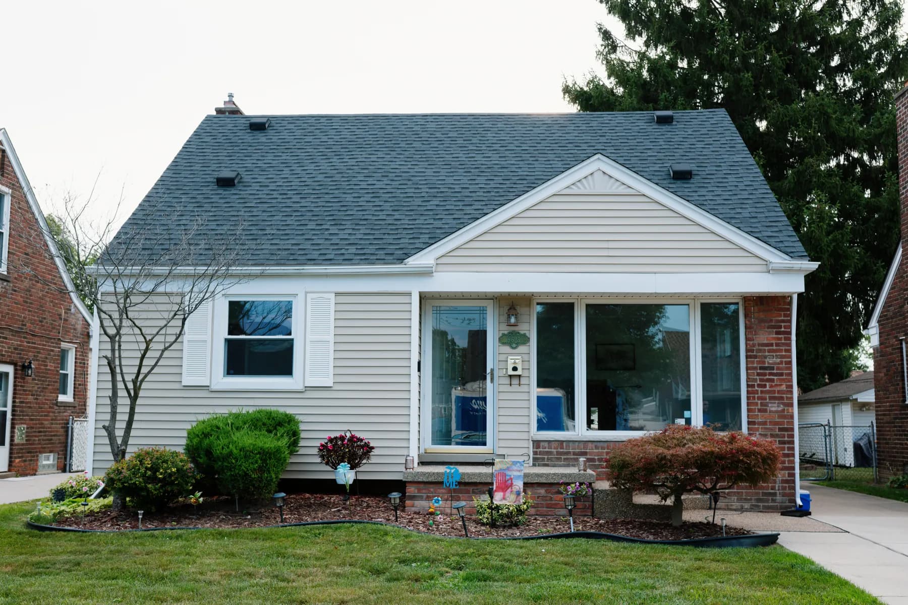Full front of a vinyl-sided cape with new windows in Taylor