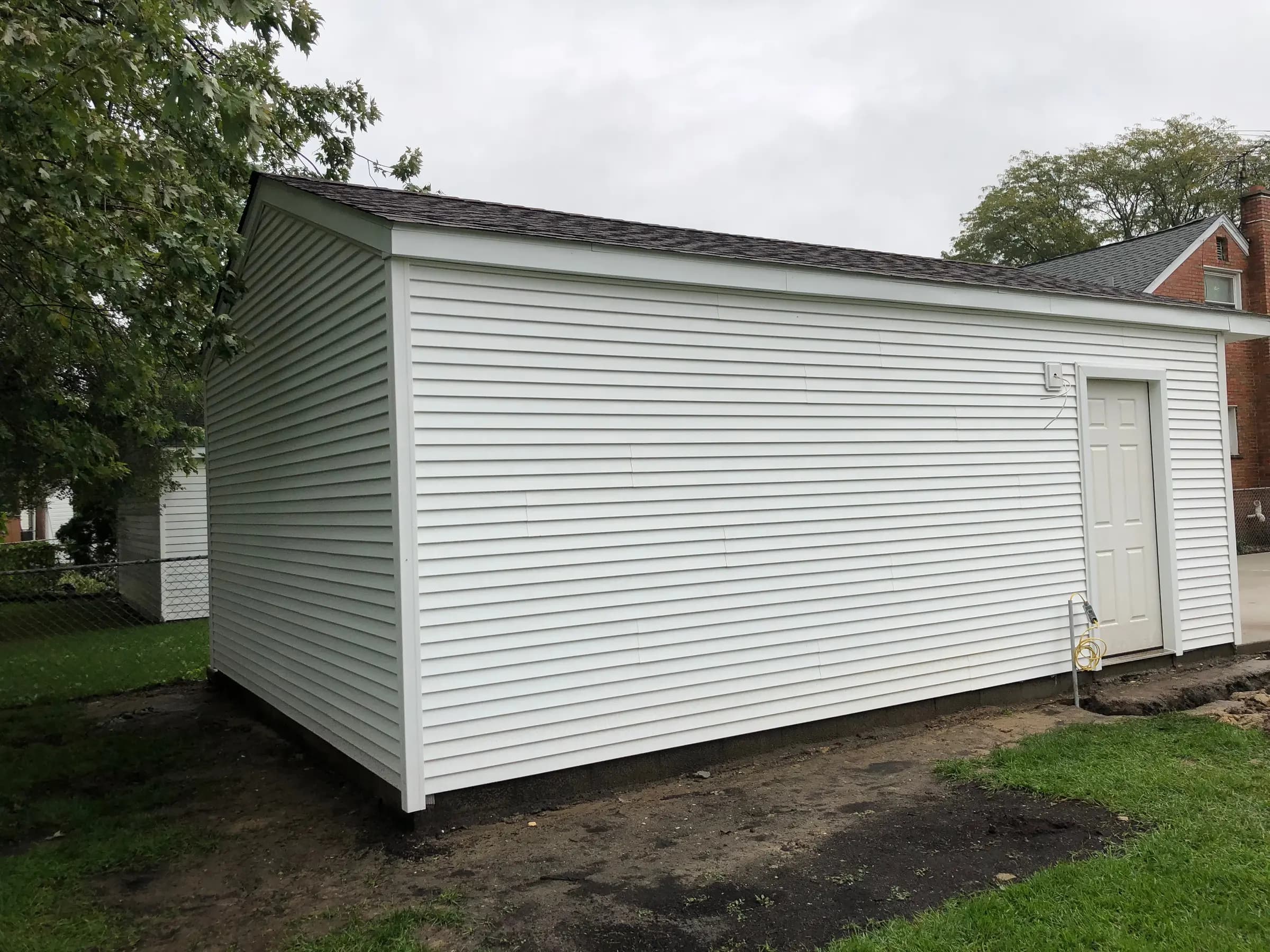 Freshly hung vinyl siding on a detached garage