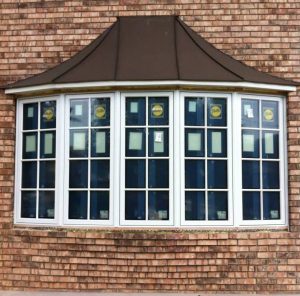 Beautiful bow window configuration with five windows set on exterior brick wall