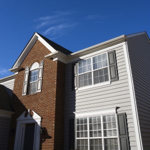 Detail of one-half of two-story home with lap siding and double-hung windows